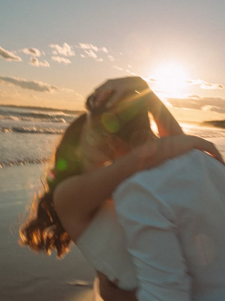 Casal se beijando ao pôr do sol